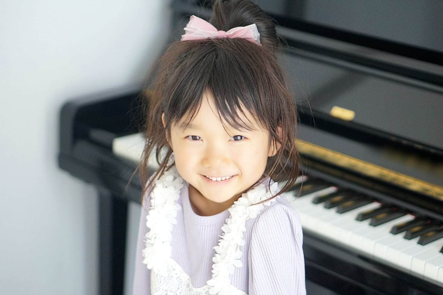 ピアノの前で笑顔の子ども